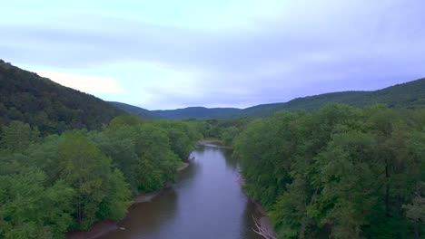 Long-Drone-aerial-of-the-Susquehanna-river-passing-trees-in-Pennsylvania