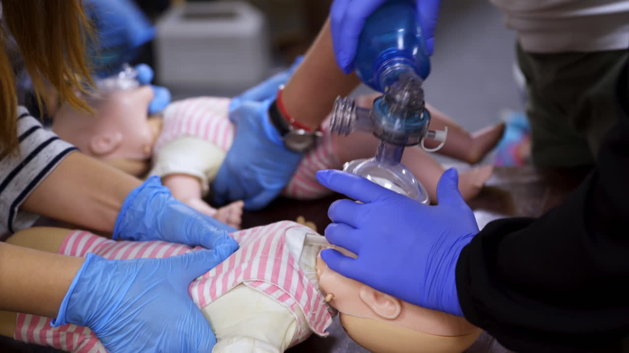 Practice of chest compression on dolls. Students teaching cardiopulmonology procedure for giving first aid on a mannequin in medical center. Close-up.