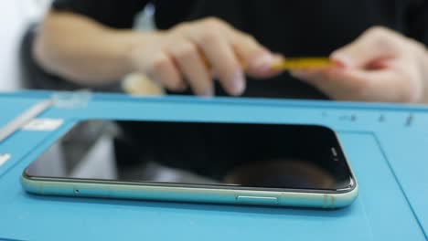 smartphone repair: technician fixing a phone screen