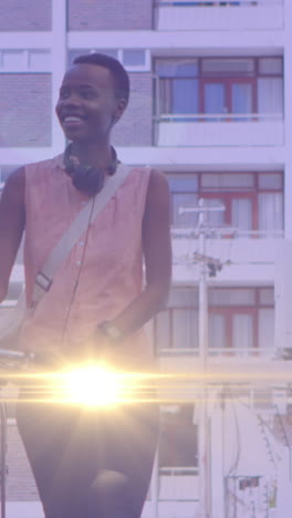 animación de puntos de luz sobre una feliz mujer afroamericana caminando en bicicleta