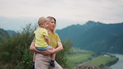 Glückliche-Frau-Mit-Kleinem-Sohn-Genießt-Die-Aussicht-In-Der-Nähe-Der-Berge