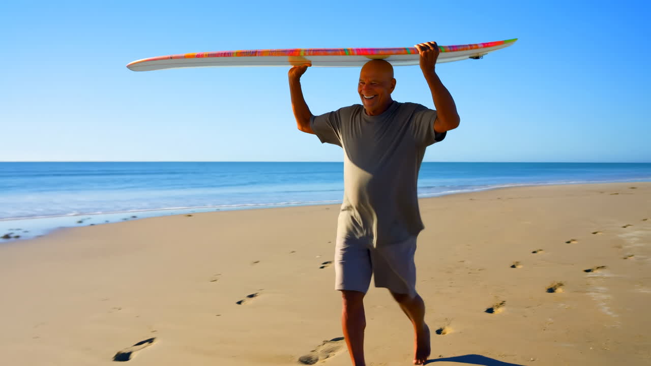 Uomo Anziano Felice che Cammina sulla Spiaggia con Tavola da Surf