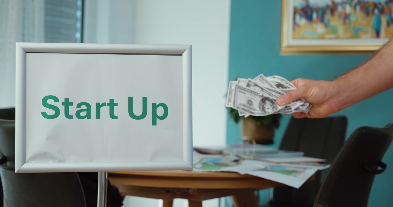 Startup funding concept with hands holding cash, representing business investment, venture capital, financing, entrepreneurship, and company growth.