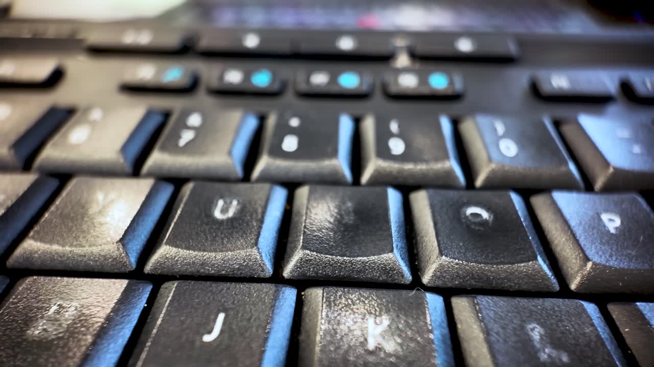 Close Up of a Black Computer Keyboard with Worn Lettering and Aged Keys Showing the Letters U I O P J K L and C for Technology Concepts