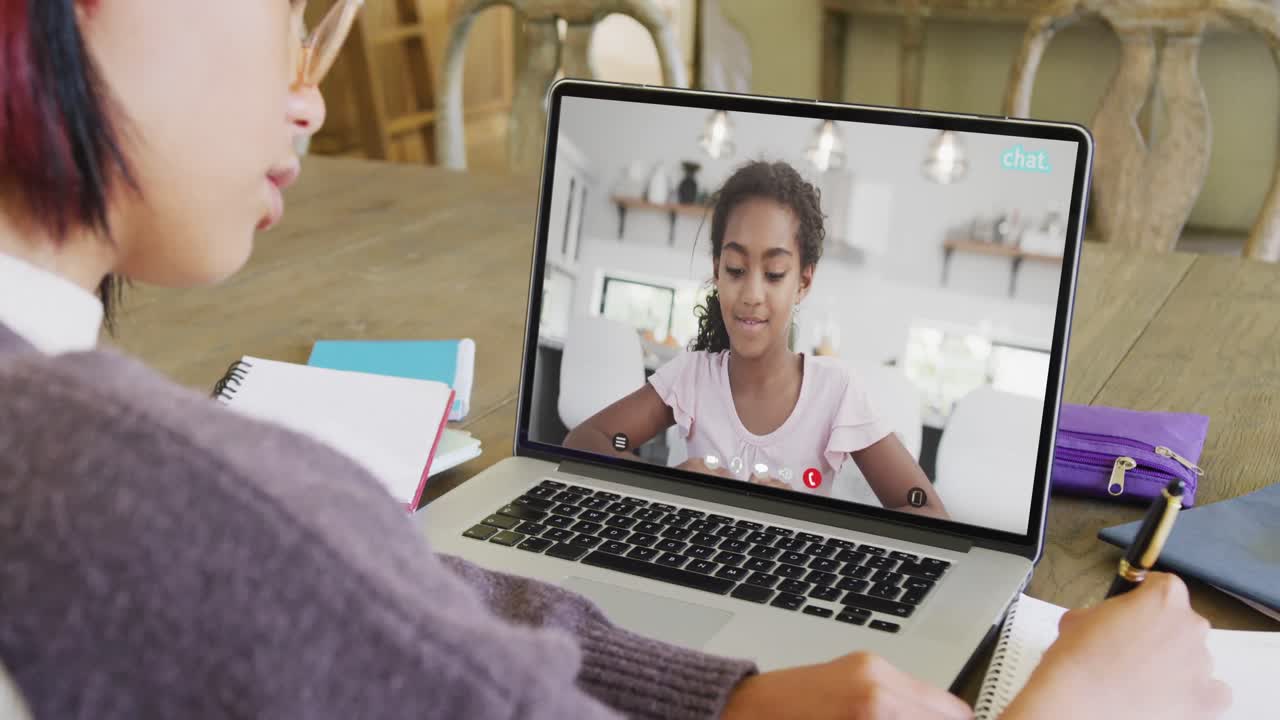 estudiante asiática teniendo clase en laptop llamada de video con amigo biracial en cámara lenta