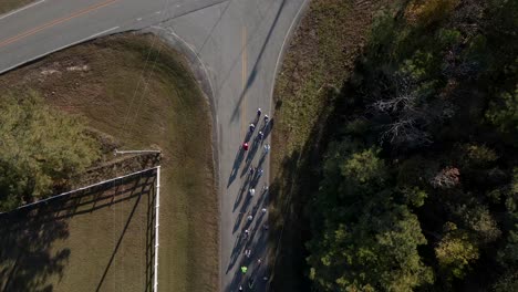 giro aéreo de drones de ciclistas que redondean la curva