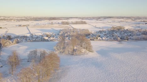 Winterlandschaft-In-Der-Nähe-Eines-Dorfes-Mit-Großen-Häusern-Und-Mit-Weißem-Schnee-Bedeckten-Feldern-An-Einem-Hellen,-Kalten-Tag-In-Schottland-Während-Der-Goldenen-Stunde