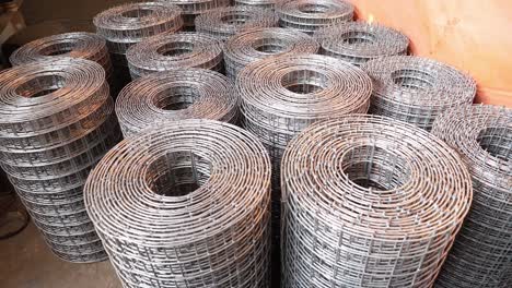 stacked wire mesh rolls on floor. circle dolly