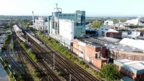 industrial chemical manufacturing factory next to warrington bank quay train tracks aerial view low to high