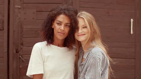 una pareja de lesbianas multiétnicas posando al aire libre