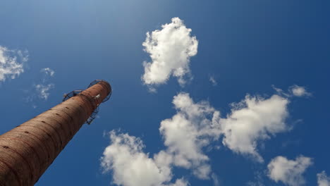 old chimney with fluffy clouds and blue sky in the background