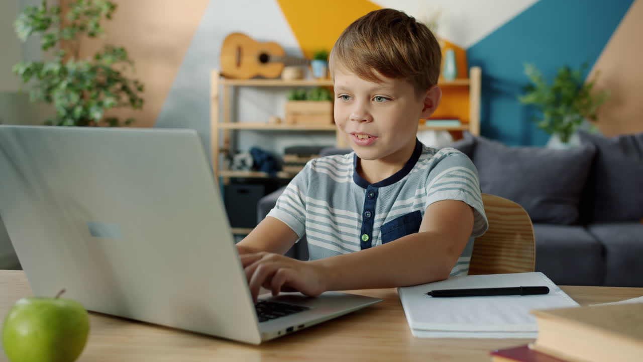 Child Studying at Home with Laptop and Notebook