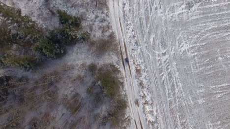 Vater-Mit-Kind,-Das-Im-Winter-Ein-Atv-In-Der-Nähe-Des-Waldes-Fährt