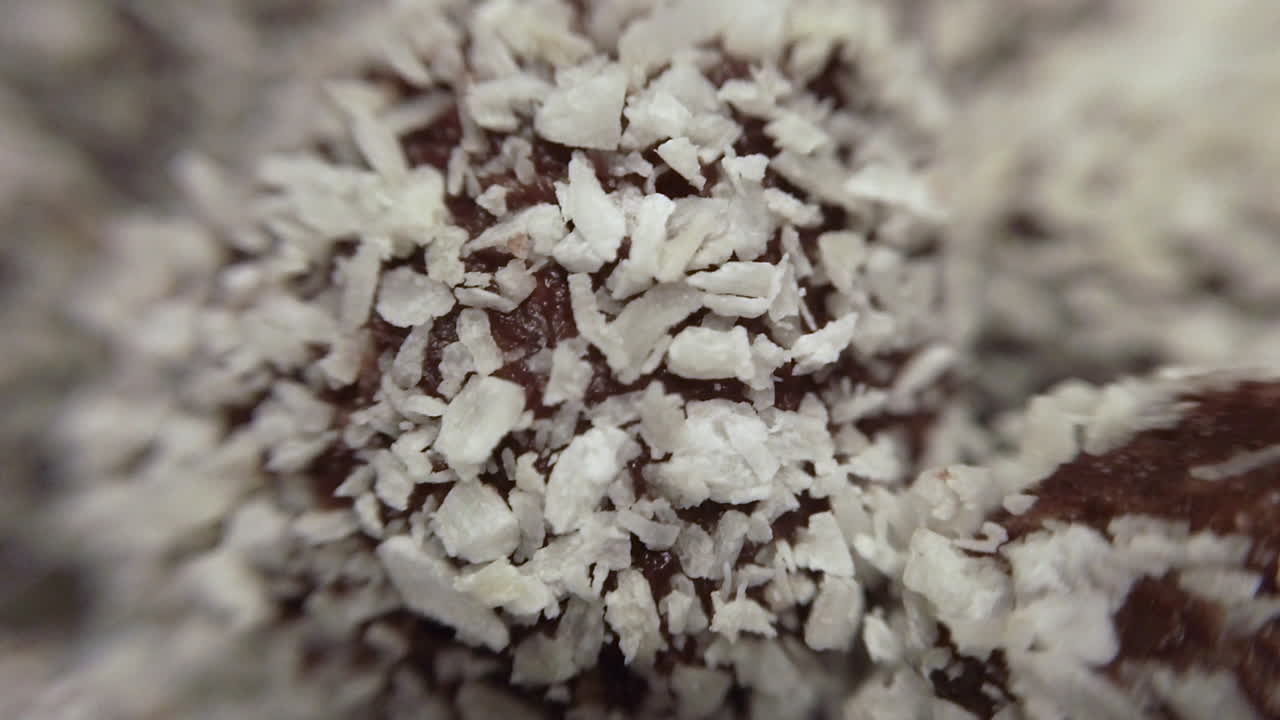 Scatto macro ravvicinato che si muove su deliziose palline di cioccolato di pasticceria con scaglie di cocco. Pasticceria tradizionale svedese.