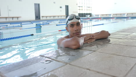 Un-Joven-Atleta-Birracial-Nadador-Descansa-Junto-A-La-Piscina,-Con-Espacio-Para-Copiar