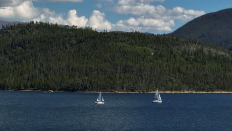 Antena-Cinematográfico-Zumbido-Zoom-Dos-Veleros-Navegación-Lancha-Motora-Lago-Dillon-Colorado-Verano-Cielo-Azul-Nubes-Durante-El-Día-Frisco-Silverthorne-Embalse-Puerto-Pequeño-Breckenridge-Piedra-Angular-Circulo-Derecho-Movimiento