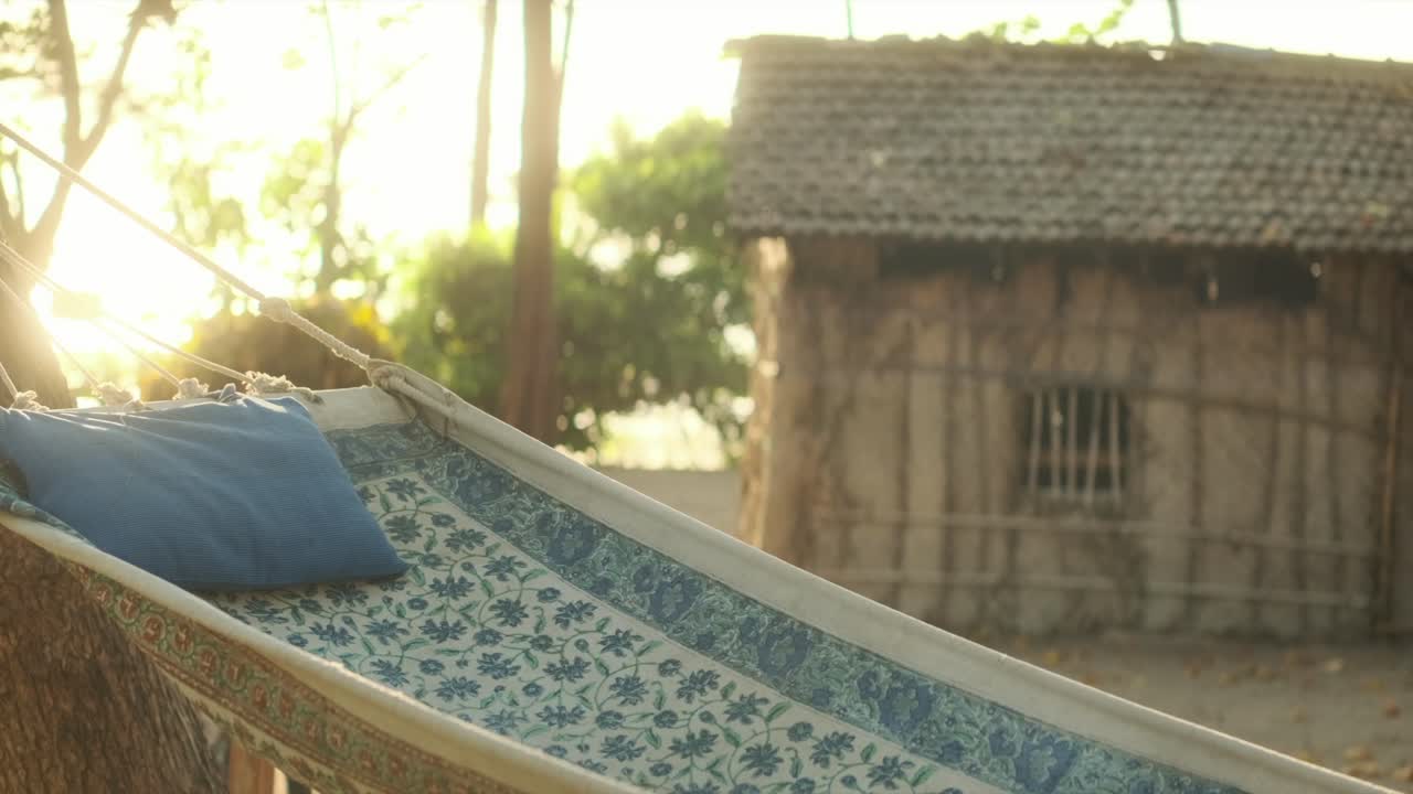 해가 지는 해변의 햄록과 오두막