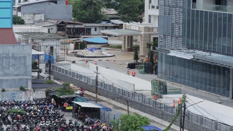 building under construction in the city of jakarta with workmen at the front entrance facade