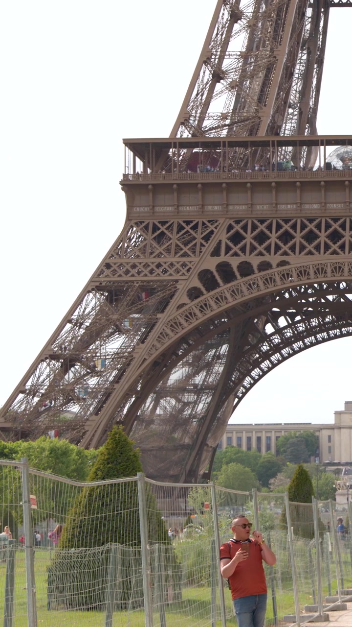 Turista in posa per una foto davanti alla Torre Eiffel a Parigi