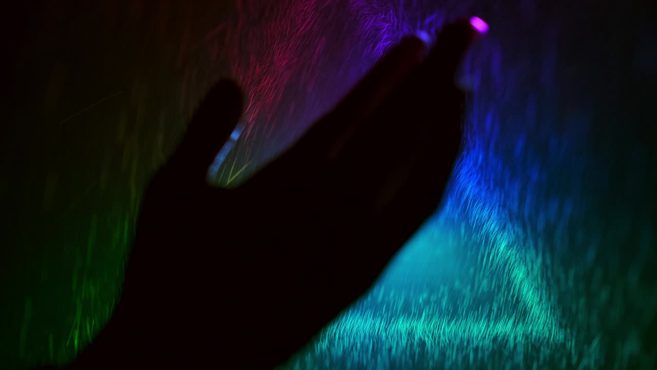 An Amazing Triangle. Hand Moves On Triangle Background With Colored Light. Splashes Of Water Fly On Hand.