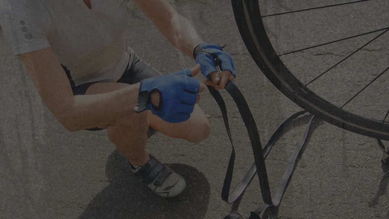 Mature woman kneeling paved road pulling tube following flat tire inspecting valve for bike repair
