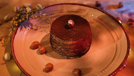 plate of chocolate crepe cake with pistachio on the party table