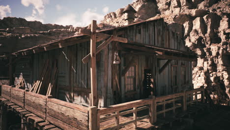 cabaña de madera abandonada en un paisaje accidentado bajo un cielo azul