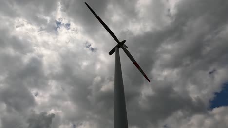 Tiefwinkelaufnahme-Einer-Windkraftanlage,-Die-An-Einem-Bewölkten-Tag-Rotiert-Und-Erneuerbare-Energie-Erzeugt,-4k