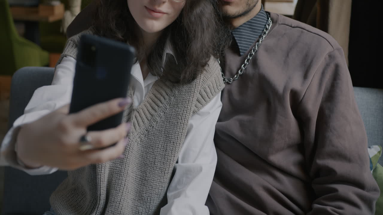 una pareja tomando una selfie en un café.