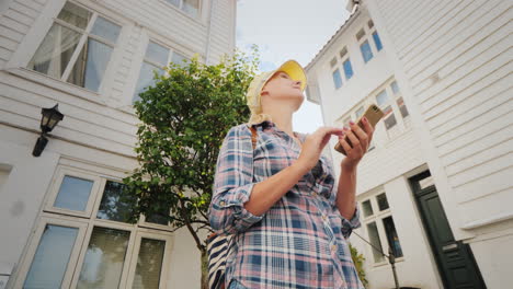 Tourist-With-A-Map-In-Her-Hands-Walking-Through-The-Narrow-Streets-Of-Bergen-In-Norway-Holidays-In-S