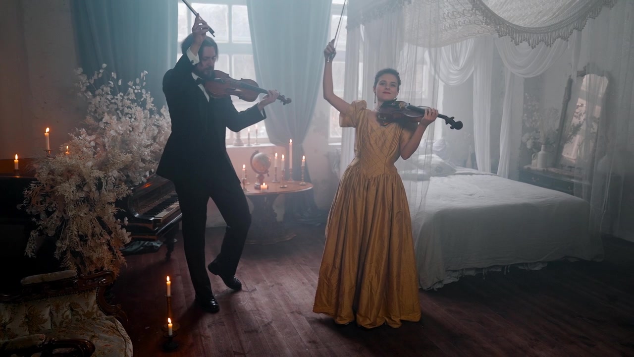 Homem e Mulher Elegantes Tocando Violinos em uma Sala Vintage à Luz de Velas