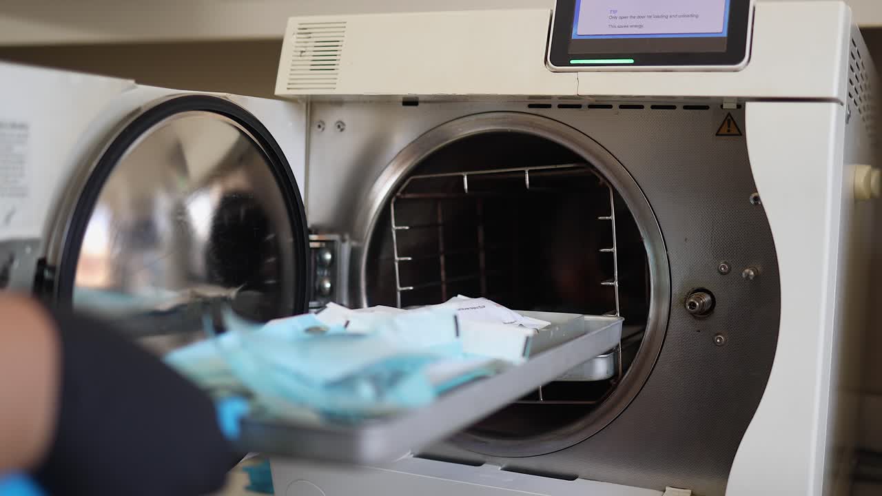 Disinfected dental instruments are removed from autoclave machine