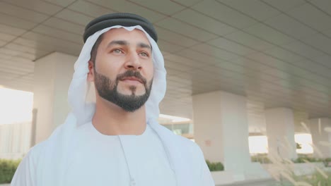 close up low angle portrait of arabic uae man wearing kandoora and ghutra looking far away