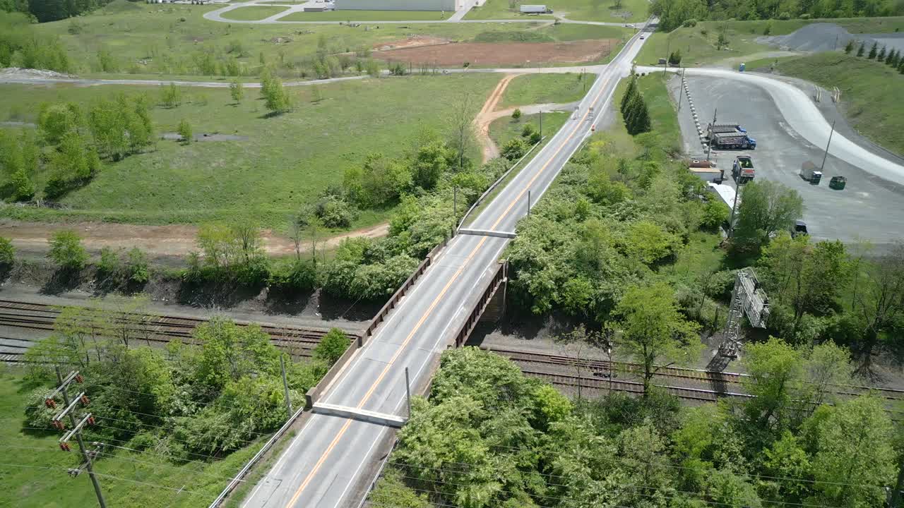 Aerial drone view of a bridge going over a railroad.
