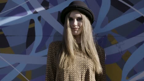 stylish woman posing by graffiti wall