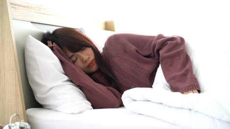 Asian-woman-sleeping-on-bed-in-morning