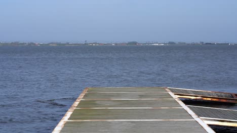 wood pier against river and riverbank