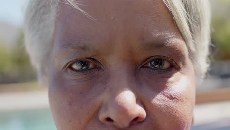 portrait close up of happy senior biracial woman in sunny garden, unaltered, in slow motion