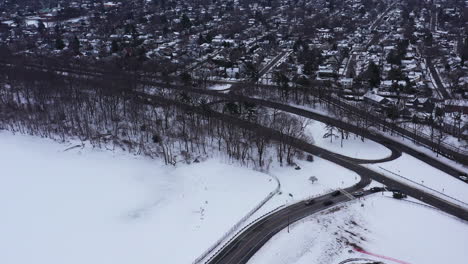 An-aerial-view-from-a-drone,-over-a-frozen-lake-during-sunrise-on-a-cloudy-morning