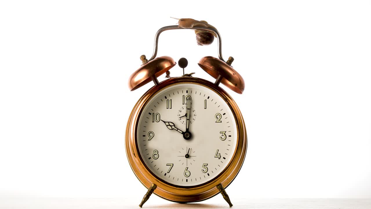 CLock hand spinning fast time lapse. Clock hand spinning fast on vintage bronze alarm-clock on white background.