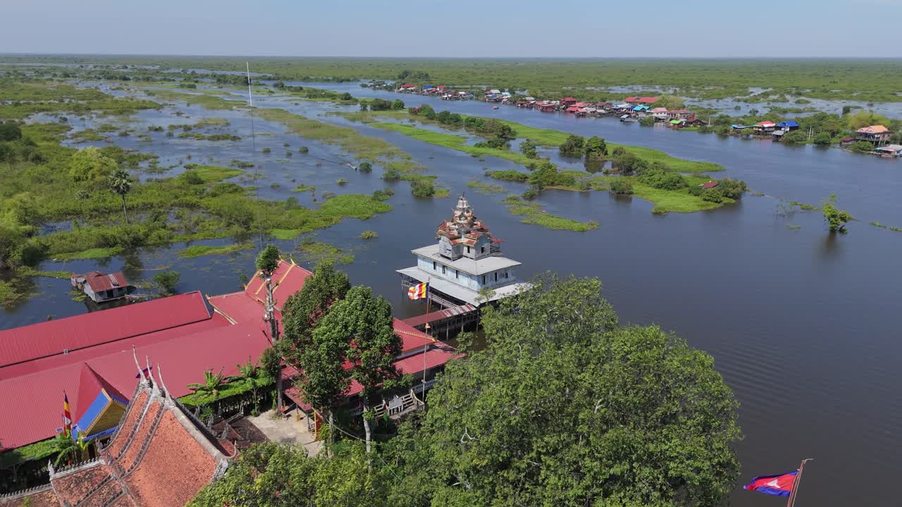 Daily life at old wooden monastery on the main transport water way with lush green vegetation from Siem Reap to Battambang in original condition. Drone aerial orbit rotate