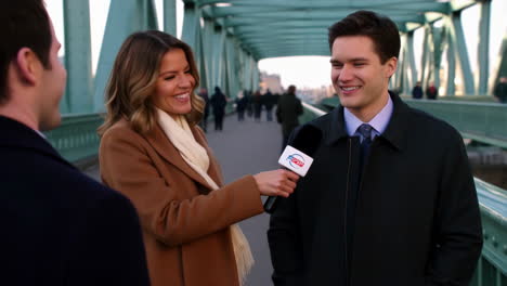 reporter interviews man on a bridge