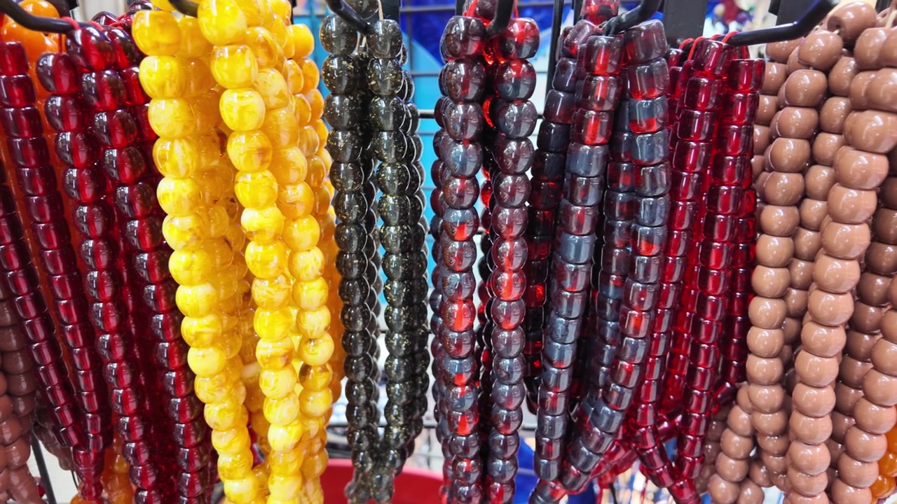 Rosari colorati appesi su un espositore