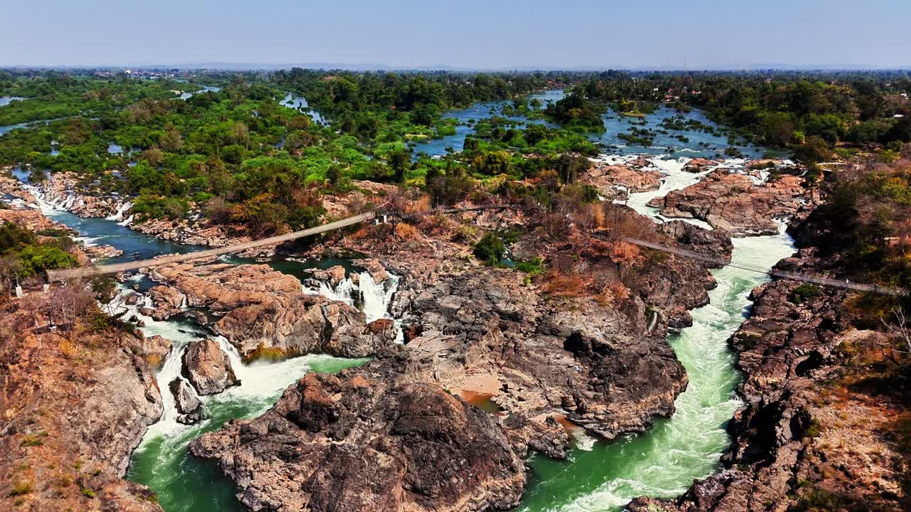 Aerial shot of Mekong River carving through rocky terrain near Don Det in the Si Phan Don - Four Thousand Islands region of southern Laos, with rapids and channels weave through lush tropical wetlands