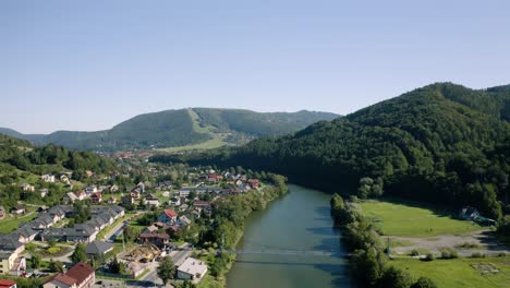 paisaje de beskidy polaco, pequeño pueblo situado junto a un río y montañas boscosas