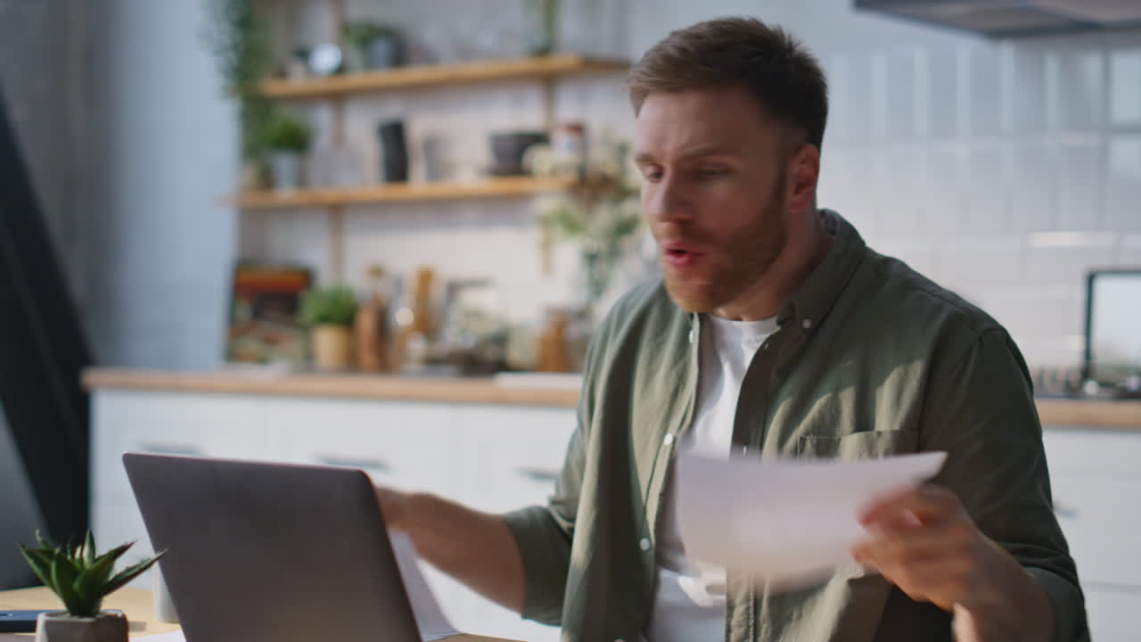 Businessman arguing video call laptop holding work documents at home closeup
