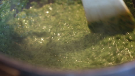 stirring in a cooking pan with spinach. [4k