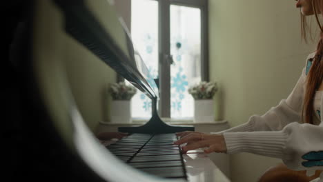 una chica asiática bonita toca el piano en casa en un ambiente acogedor