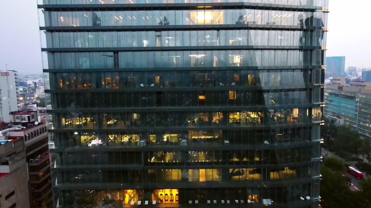 Vista aérea de uma torre de vidro com várias lojas, como ginásios, centro de reuniões, restaurantes e hotel.