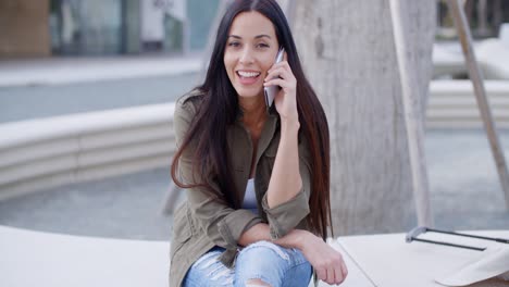 una estudiante joven y bonita hablando en su móvil.